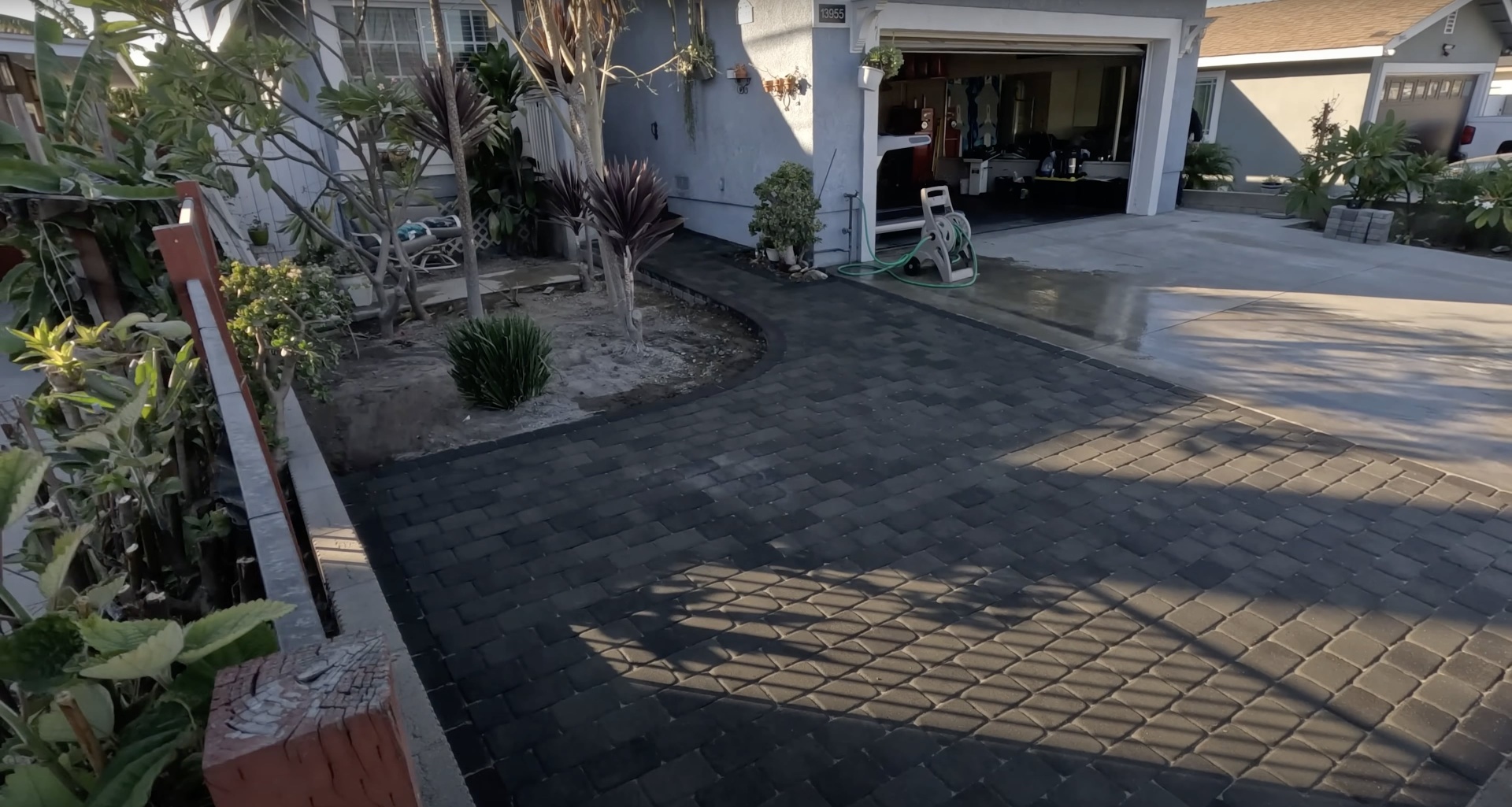 Decorative stamped concrete driveway installation Beautiful stamped concrete driveway with decorative patterns and professional landscaping