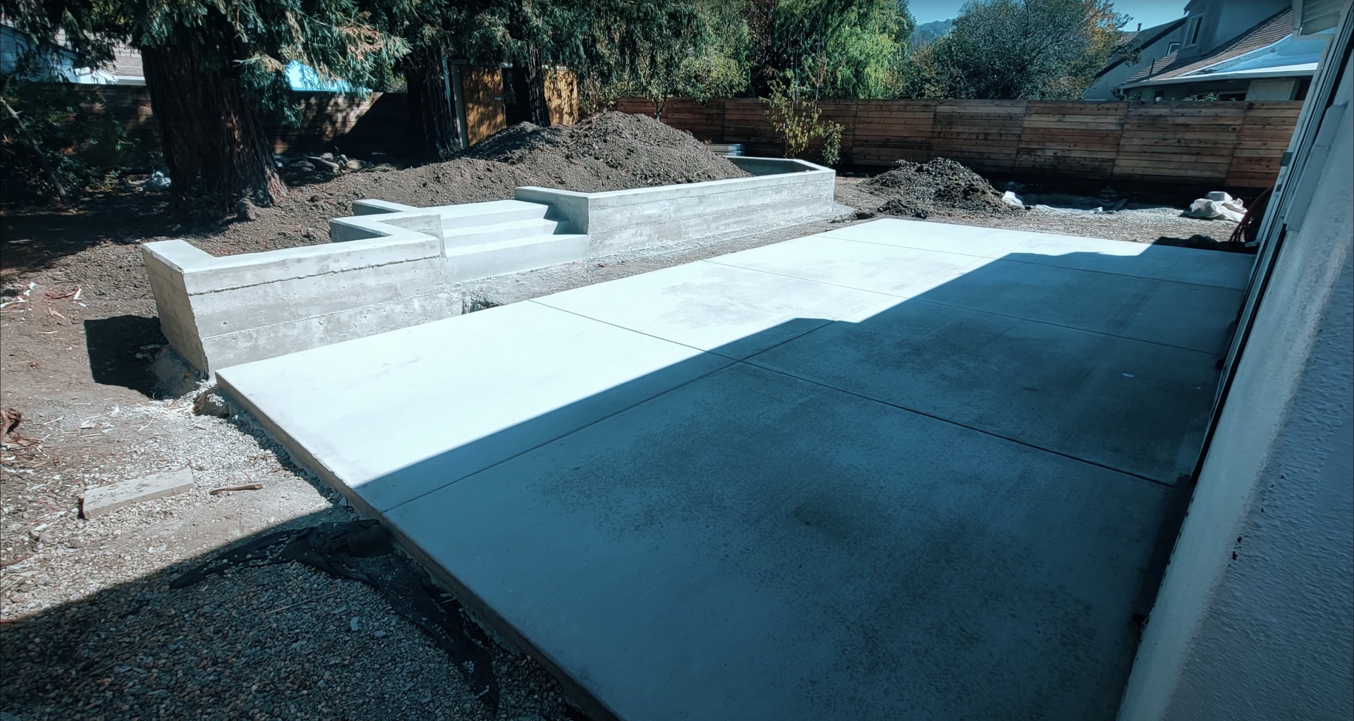 Contemporary concrete patio and retaining wall project Modern concrete patio and retaining wall construction showing clean lines and professional finish