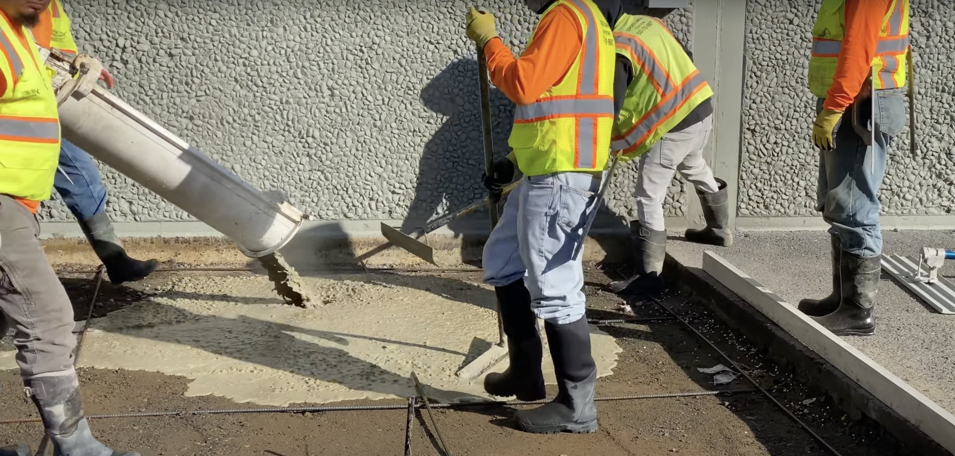 Expert concrete pouring and finishing techniques Concrete construction workers pouring and finishing concrete with professional equipment